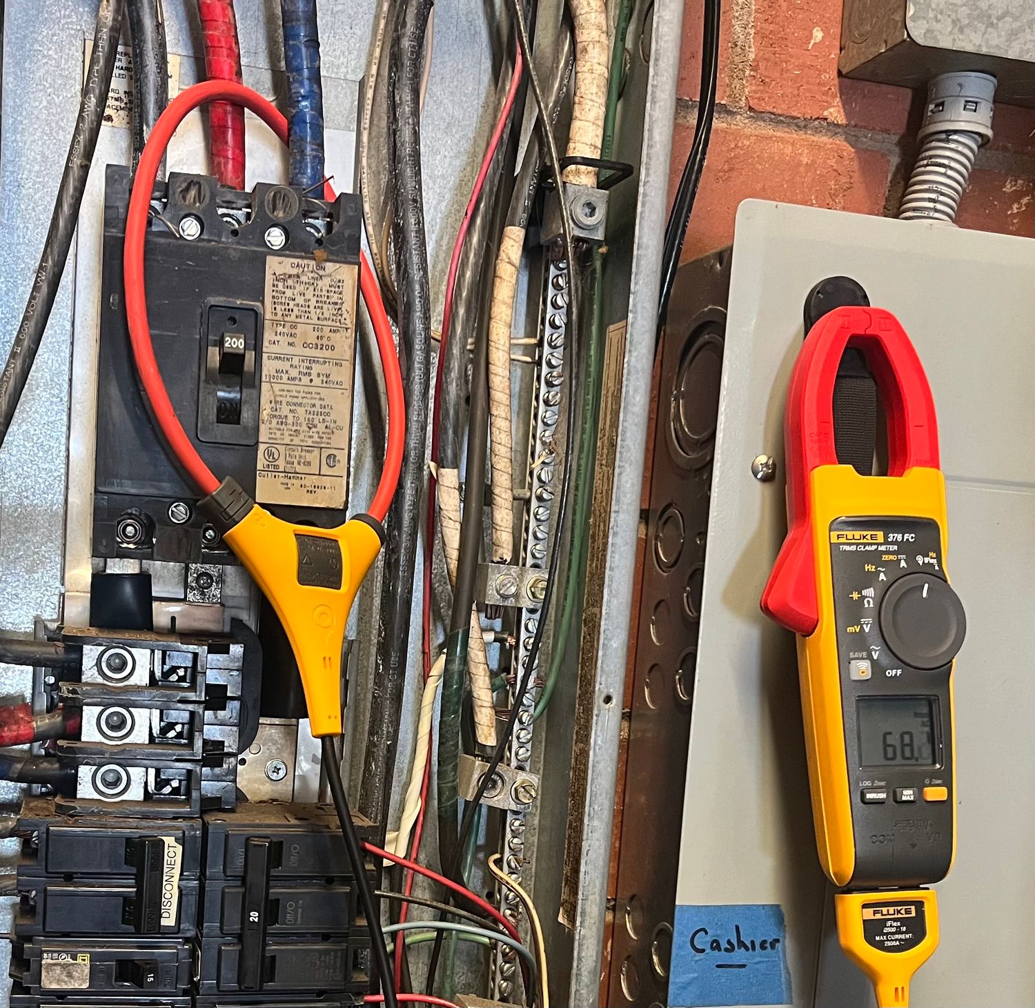 Bobby Shaver diagnosing a commercial electrical panel with a Fluke clamp meter